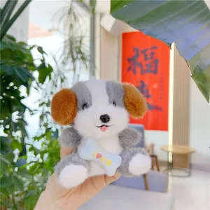 Detalle de llavero de perro de peluche con pajarita de hueso azul y bordado Love