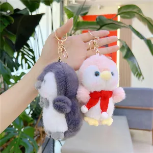 Cute plush penguin keychain set in grey and pink with fluffy fur and gold clasp