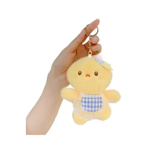 Cute yellow plush chick keychain wearing blue checkered apron and star hair clip