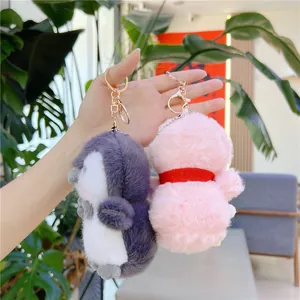 Plush penguin and pink animal backpack charms with fluffy texture and gold keyrings