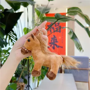 Brown plush pony keychain with golden ring and realistic mane shown in hand