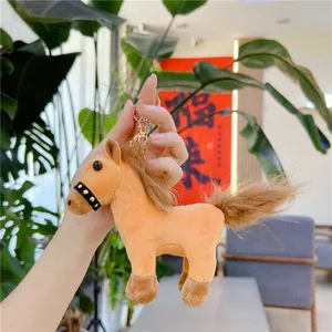 Close-up of a camel plush horse keychain with brown mane and golden metal carabiner