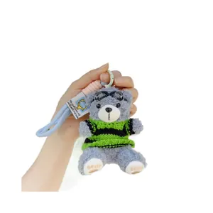 Süßer grauer Teddybär-Plüschanhänger mit gestreiftem Pullover und Fliegerbrille