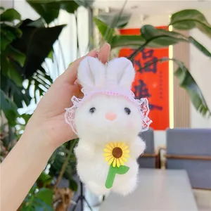 Detail van witte pluche konijn met roze kantmuts en gele zonnebloem decoratie
