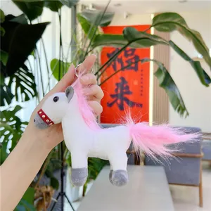 Detailed close-up of a white plush unicorn keychain with pink fur and metal ring