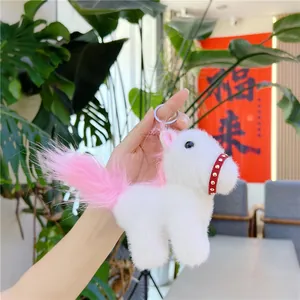 Mini white plush pony keychain with pink mane and metal ring shown in hand