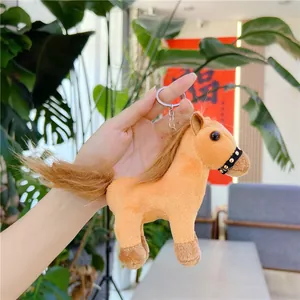 Detailed close-up of orange plush horse keychain with silver metal ring and bridle details