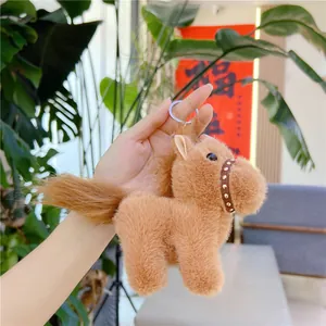Detailed close-up of brown plush pony keychain with leather collar and metal ring