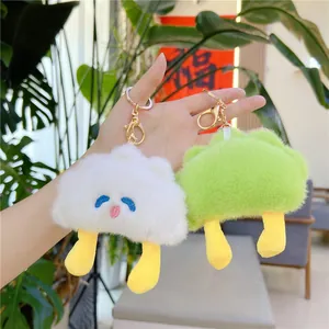 Close-up of cute plush cloud keychains in white and green with gold metal clips
