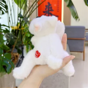 Detail showing the red heart-shaped button and soft white plush fur on small toy