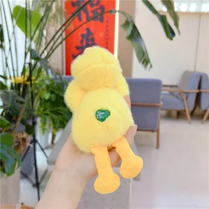 Close-up of yellow plush duck doll with a green heart-shaped brand tag on the back