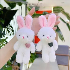 Lot de porte-clés lapin en peluche avec cœur, présenté en main pour la perspective