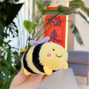 Dettaglio di un portachiavi a forma di ape in peluche con ali viola e strisce gialle