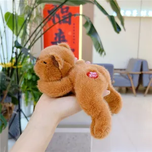 Close-up of palm-sized brown plush bear toy with red heart tag held in hand