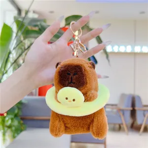 Close-up of brown capybara plush keychain with a yellow duck swim ring and gold clasp