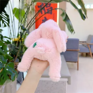 Detailed view of a soft pink plush rabbit toy with a decorative green back button