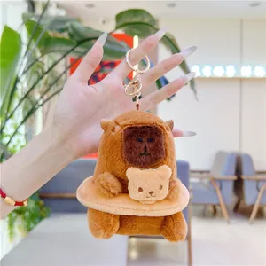 Detail of plush capybara keychain with bear swim ring and gold lobster clasp