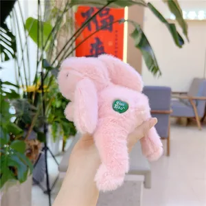 Detailed view of pink plush bunny toy featuring a green heart-shaped brand accessory