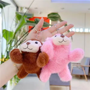 Close-up of pink and brown plush monkey keychains with soft faux fur and metal rings