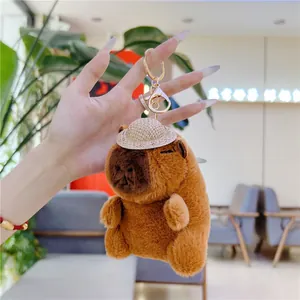 Dettaglio del portachiavi peluche capibara con cappello di paglia e chiusura dorata