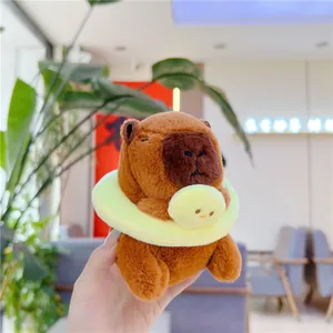 Close-up of soft brown capybara plush keychain with a yellow fuzzy neck ring detail