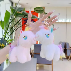 Plush unicorn keychains in pink and white with soft fur and metallic gold clasp