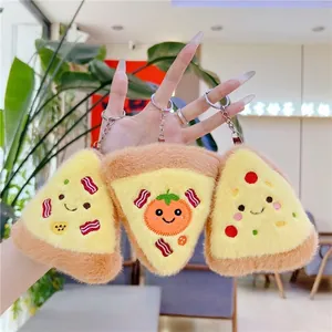 Tre simpatici portachiavi a forma di pizza in peluche con ricami in un ambiente reale
