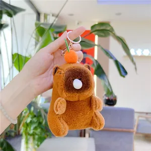 Close-up of plush capybara keychain with orange fruit accessory and funny bubble nose