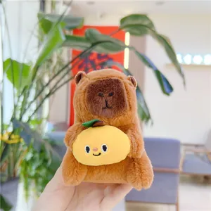 Close-up of a cute capybara plush keychain holding a yellow lemon with a smiling face