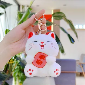 Close-up of white plush lucky cat keychain with Pingan embroidery and gold clasp