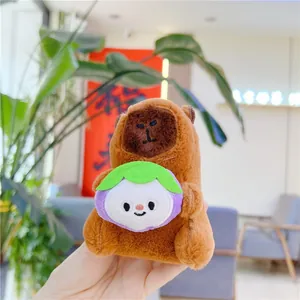 Detailed view of plush capybara keychain holding a purple mangosteen fruit toy