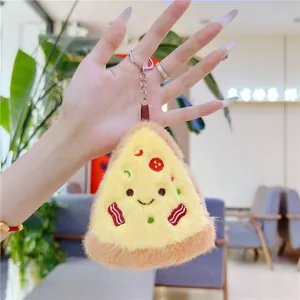 Close-up of a cute plush pizza keychain with embroidery detail held in hand