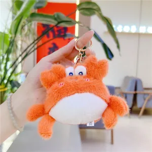 Détail d'un porte-clés crabe en peluche avec étiquette faite main et fermoir doré