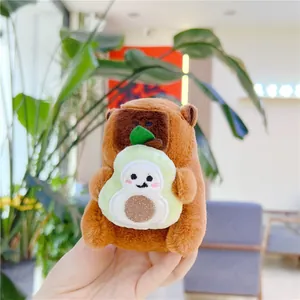Close-up of cute plush capybara keychain holding an avocado with soft furry texture