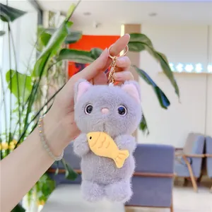 Cute grey plush cat keychain holding a yellow fish, soft faux fur accessory for bags