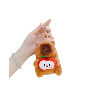 Cute plush capybara keychain holding a red apple with a gold ring clasp toy