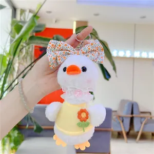 Detailed close-up of plush duck keychain featuring floral bow and sunflower embroidery