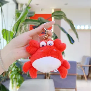 Détail d'un porte-clés crabe en peluche rouge avec texture douce et fermoir doré