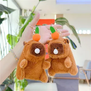 Macro shot of Capybara plush keychain with a small orange on head and golden metal clasp