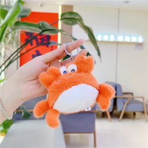 Gros plan d'un porte-clés crabe en peluche orange avec de grands yeux bleus