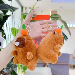 Plush Capybara keychains with orange fruit decor and shaking sound feature held in hand