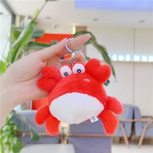 Gros plan d'un petit porte-clés crabe en peluche rouge avec un anneau métallique