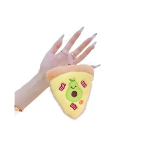Plush pizza keychain with avocado embroidery held by hand on a white background