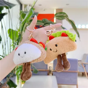 Macro detail of funny plush hot dog and taco charms with embroidery and gold keychains