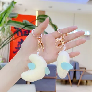Detail of plush crescent moon keychains with small blue wings and golden lobster clasps