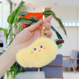 Dettaglio del portachiavi in peluche a forma di frutto giallo con ricamo e clip dorata