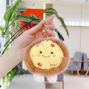 Close-up of cute plush pizza keychain with smiling face and golden metal lobster clasp