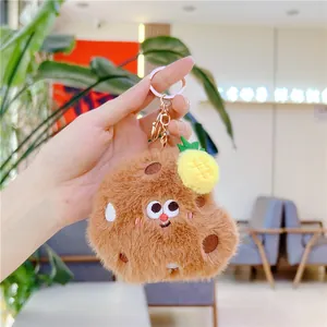 Close-up of plush cookie keychain with pineapple charm and golden lobster clasp