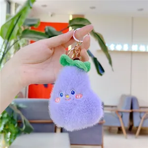 Dettaglio del ciondolo a melanzana in peluche viola con foglie verdi e portachiavi d'oro