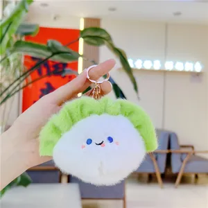 Macro detail of a plush cabbage keychain with cute embroidery and gold metal clip